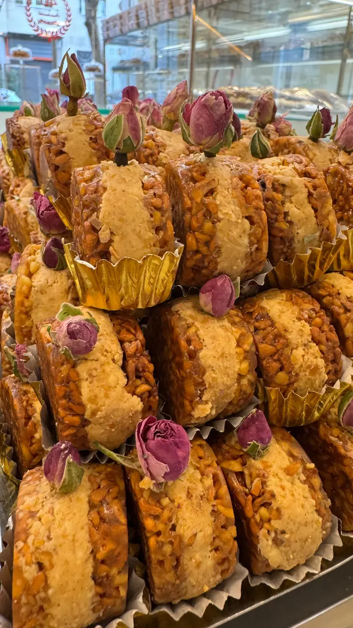 Nos gâteaux aux fruits secs et au miel, glacés et coiffés chacun d'un bouton de rose séché, dressés en pyramide.
