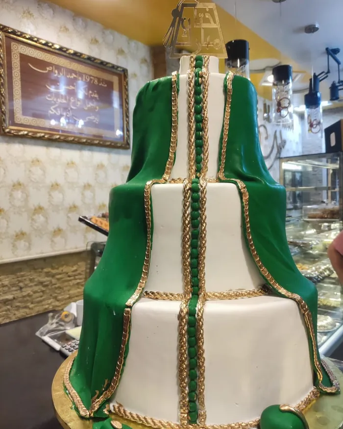 Une pièce de fête à étages, glaçage vert et blanc rehaussé d'or, façon takchita, sur commande.